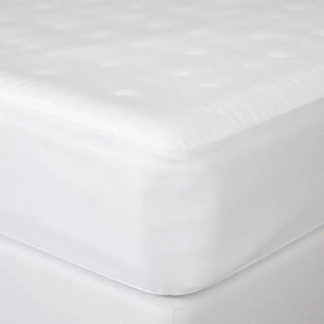 A deep fitted sheet perfectly hugging the corner of a thick mattress